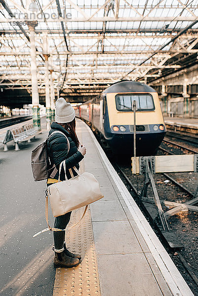 Frau wartet auf dem Bahnsteig im Bahnhof  Edinburgh  Schottland