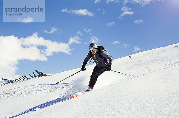 Erwachsener Mann fährt mit Skiern den schneebedeckten Berg hinunter  Steiermark  Tirol  Österreich