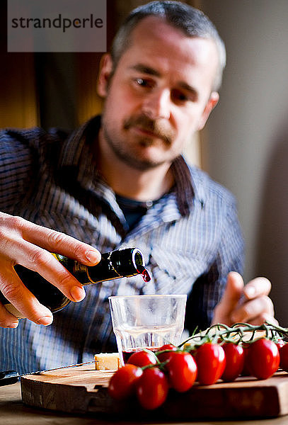 Mann trinkt Wein und isst mediterranes Essen im Café