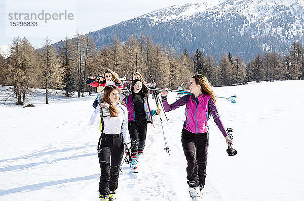 Fünf jugendliche Skifahrerinnen wandern in verschneiter Landschaft  Tirol  Steiermark  Österreich