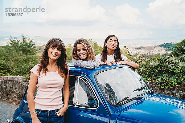 Frau steht neben Freunden und posiert im Autoschiebedach  Florenz  Toskana  Italien