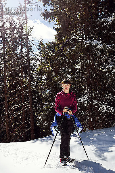 Jugendliches Mädchen beim Schneeschuhwandern im verschneiten Bergwald  Porträt  Steiermark  Tirol  Österreich