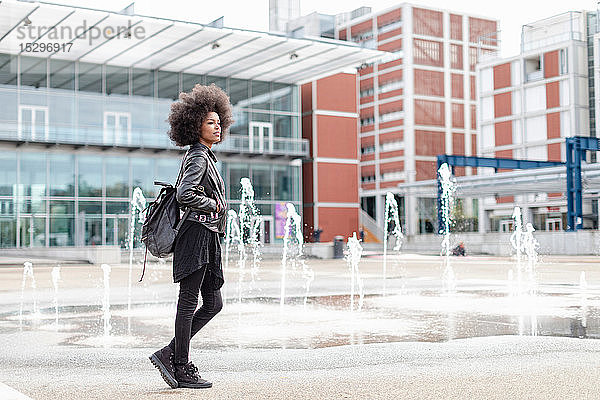 Coole junge Frau mit Afro-Haaren in der Stadthalle  in voller Länge