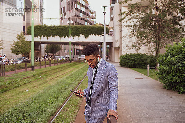 Geschäftsmann mit Smartphone auf dem Bürgersteig  Mailand  Lombardei  Italien