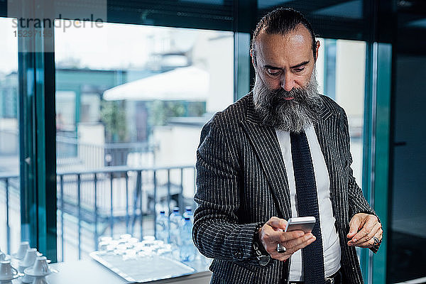Geschäftsmann mit Smartphone im Büro