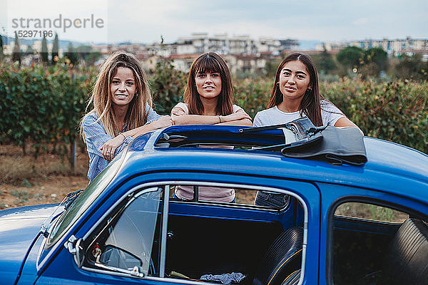 Freunde posieren neben dem Auto auf dem Land  Florenz  Toskana  Italien