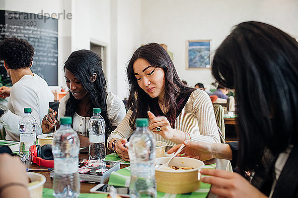 Junges männliches und weibliches Geschäftsteam beim Mittagessen im Cafe