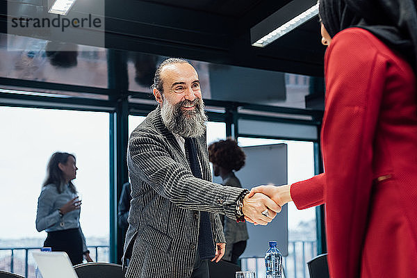 Geschäftspartner schütteln sich die Hand bei einem Treffen im Büro