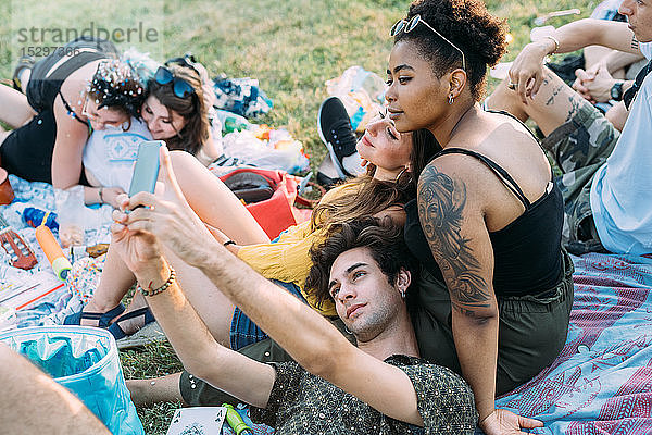 Eine Gruppe von Freunden entspannt sich  macht ein Picknick im Park