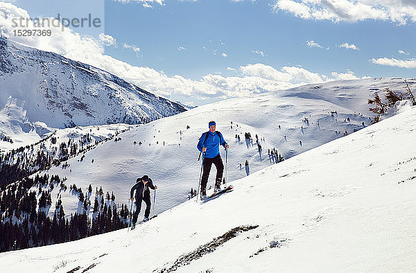 Älteres Skifahrerpaar zieht auf schneebedeckten Berg  Steiermark  Tirol  Österreich