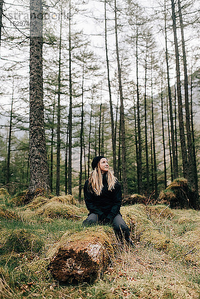 Frau sitzt auf einem Baumstamm  Trossachs-Nationalpark  Kanada