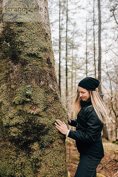 Frau berührt Baum  Trossachs-Nationalpark  Kanada