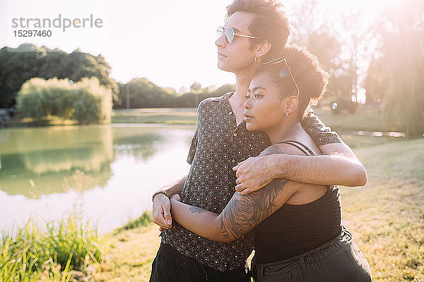 Junges Paar umarmt sich am See