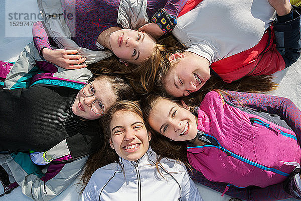 Fünf jugendliche Skifahrerinnen liegen im Kreis im Schnee  Portrait von oben  Tirol  Steiermark  Österreich
