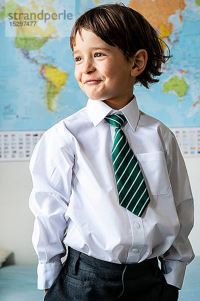 Porträt eines Jungen in Schuluniform  Weltkarte im Hintergrund