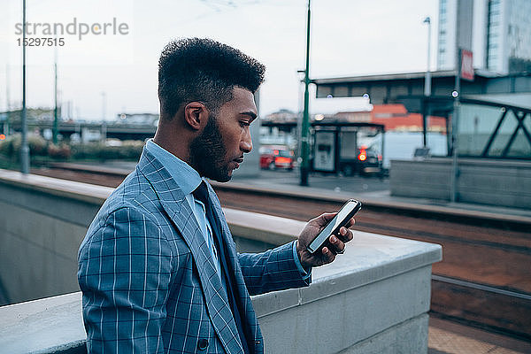 Geschäftsmann mit Smartphone auf dem Bürgersteig  Mailand  Lombardei  Italien