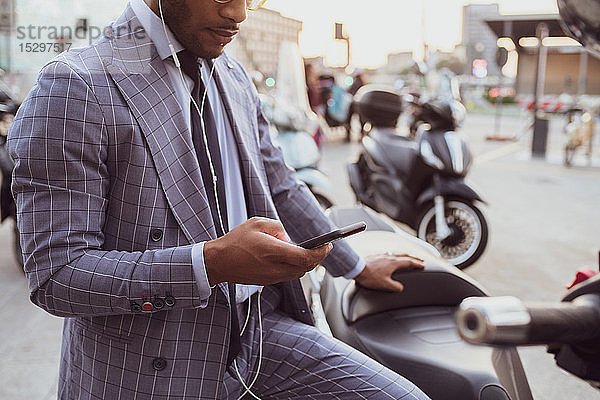 Geschäftsmann mit Smartphone auf dem Motorrad
