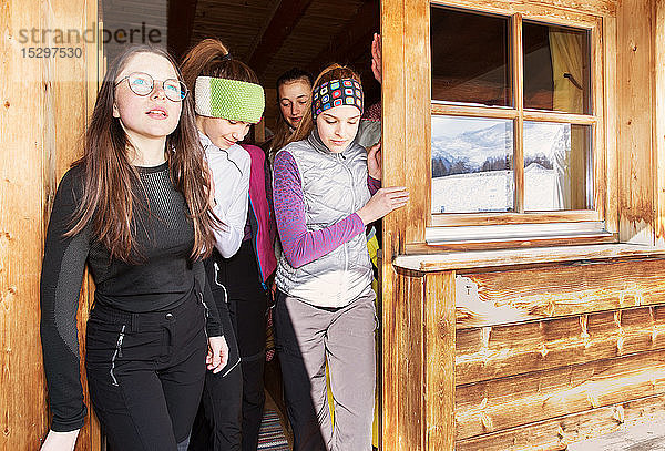 Vier jugendliche Skifahrerinnen  die von der Kabinentür aus schauen  Tirol  Steiermark  Österreich