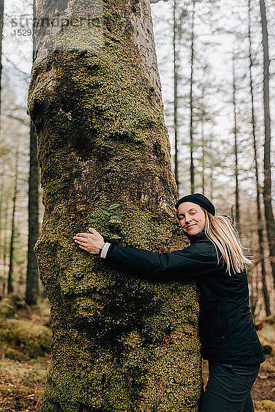 Frau umarmt Baum  Trossachs-Nationalpark  Kanada