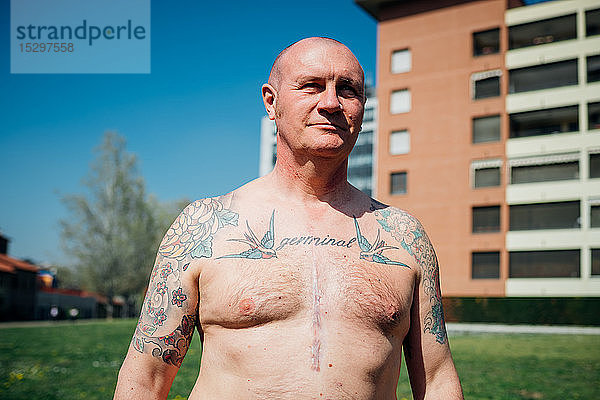 Calisthenics im Park  nackte Brust tätowierter reifer Mann  Porträt