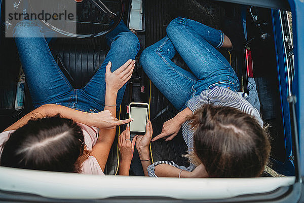 Freunde nutzen Smartphone im Auto