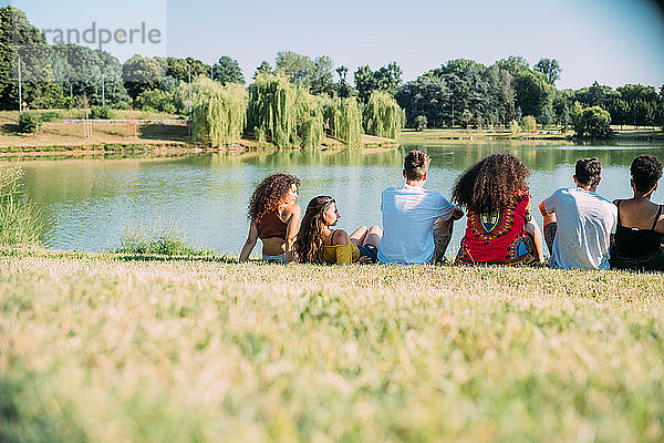 Eine Gruppe von Freunden genießt die Aussicht auf den See im Park