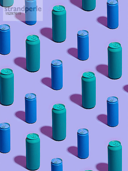 Stilleben aus türkisfarbenen und blauen Getränkedosen in diagonalen Reihen auf violettem Hintergrund