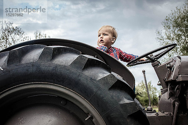 Kleinkind in Gedanken beim Traktor
