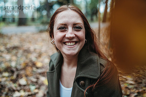 Junge Frau mit langen roten Haaren im Herbstpark  Porträt