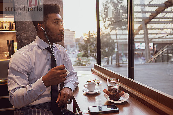 Geschäftsmann benutzt Smartphone zur Teezeit im Café