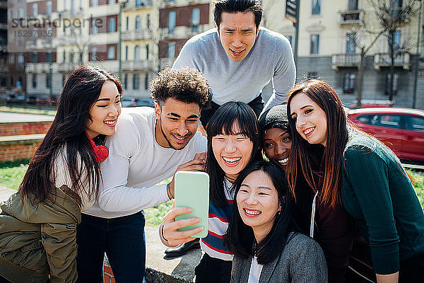Junge männliche und weibliche erwachsene Freunde nehmen Smartphone-Selfie in der Nähe der Stadtstraße