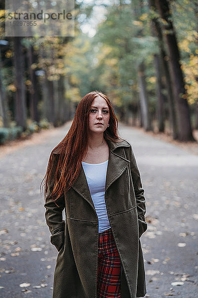 Junge Frau mit langen roten Haaren im Herbstpark  Porträt