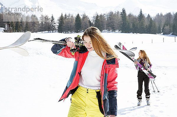 Zwei jugendliche Skifahrerinnen wandern in verschneiter Landschaft  Tirol  Steiermark  Österreich