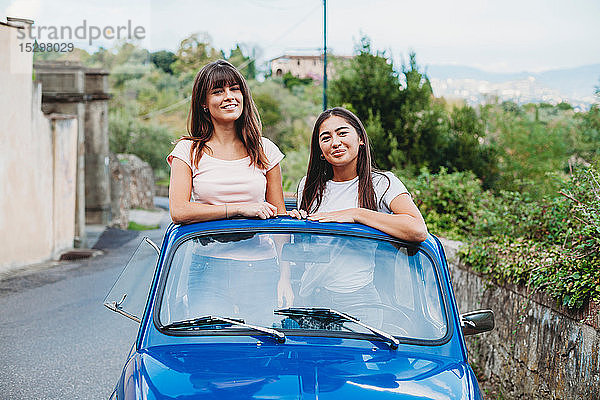 Freunde posieren im Autoschiebedach  Florenz  Toskana  Italien