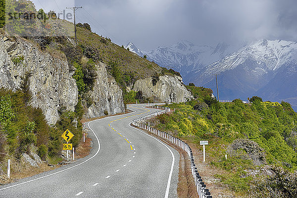 Neuseeland  Südinsel  kurvenreiche Straße in der Landschaft entlang des Hawea-Sees mit den Südalpen im Hintergrund