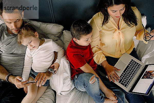 Direkt über der Aufnahme von Eltern  die Technologien einsetzen  während sie mit Kindern im Bett sitzen