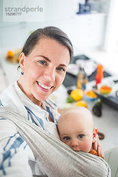 Hochwinkelporträt einer lächelnden Mutter und Tochter in der heimischen Küche