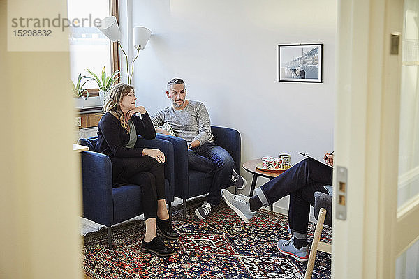 Mann und Frau im Gespräch mit dem Berater während des Workshops