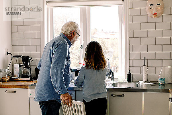 Großvater und Enkelin stehen am Tresen in der Küche