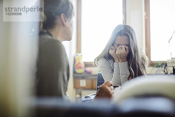 Verärgerte Teenagerin im Gespräch mit Therapeutin im Wellness-Center