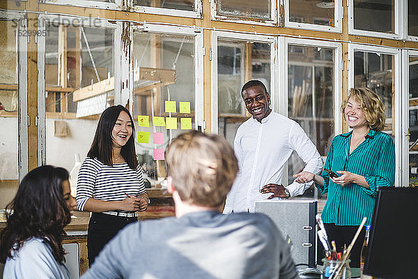 Lächelnde Unternehmer  die im Start-up-Büro an neuen IT-Projekten arbeiten