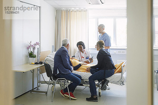Mediziner diskutieren mit der Patientin und ihren Freunden auf der Station im Krankenhaus