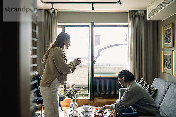 Paar im Hotelzimmer  Frau beim Fotografieren des Frühstückstabletts