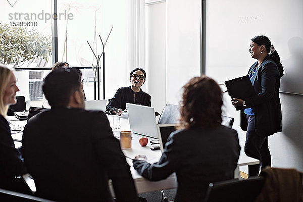 Lächelnde Geschäftsleute während einer Besprechung im Büro