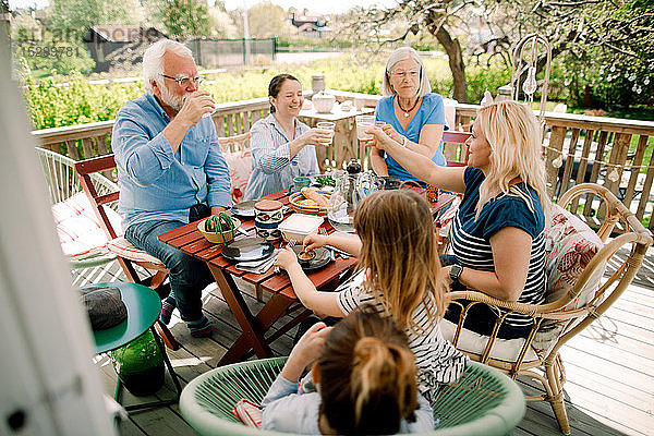 Mehrgenerationen-Familientoast auf Gläser  während man am Tisch im Innenhof sitzt