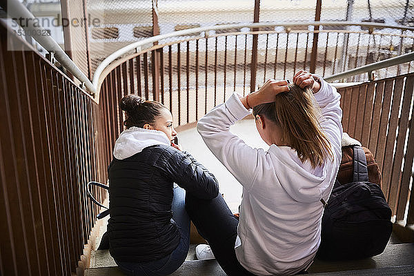 Männliche und weibliche Freunde im Teenageralter sitzen auf Stufen