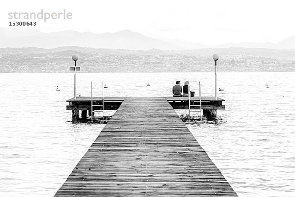Zwei Menschen auf einer Uferpromenade  Gardasee  Italien  Europa