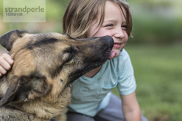 5 Jahre alter Junge wird von seinem Deutschen Schäferhund geküsst