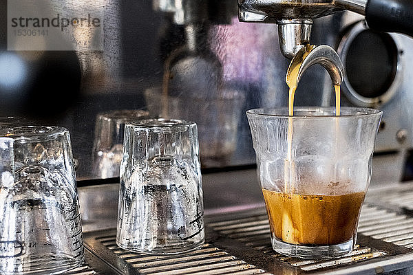Eine handelsübliche Espressomaschine in einem Coffeeshop bei der Herstellung eines Espresso-Shots.