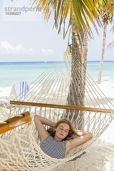 Ein jugendliches Mädchen entspannt sich in einer Hängematte am Strand